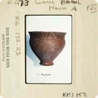 A photograph of an ancient clay pot with markings on its side.