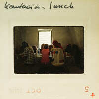 A group of people sitting around a table, possibly sharing a meal or engaging in conversation.