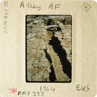 A photograph of an ancient stone structure with visible erosion and cracks.