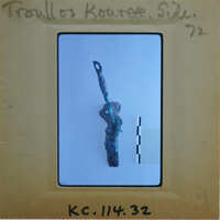 Small, greenish-brown figurine with a spear on a white background.