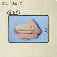 Ancient pottery fragment with visible designs on a blue background.
