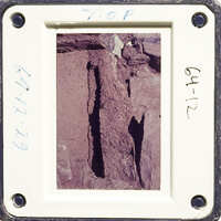 This is an image of a rock with a hole, captured on a film strip.