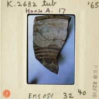 Ancient pottery shard with intricate designs on a white background.