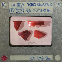 Four red glazed sherds on a white background.