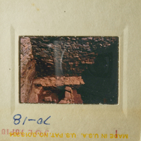 The photograph shows an interior view of a stone structure, possibly a cave or underground chamber, with a focus on the texture and structure of the walls and ceiling.