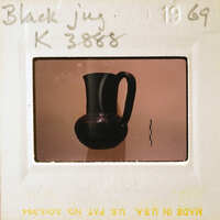 A black vase with a handle, centered against a light background.