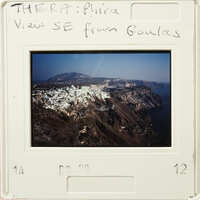 View from Goulas, showing a coastal town with houses and cliffs overlooking the sea.