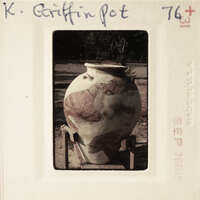 A large, multicolored clay pot with a unique pattern.