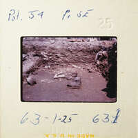 This is an old photograph showing a dirt path with rocks and debris.