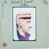 Terracotta face of figurine from side.