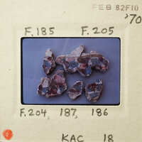 This is an image of small, colorful rocks on a white surface.