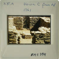 A photograph of an ancient stone structure, possibly ruins, with visible deterioration and vegetation growth.