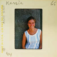 A woman posing for a vintage photograph with a handwritten name on the border.