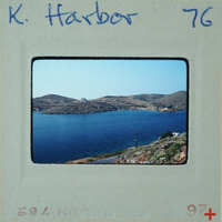 Picture of a harbor with water and mountains on a film strip.