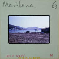 Photo of a coastal landscape with mountains, water, and buildings on a vintage film strip.