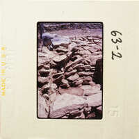 Old stone ruins with vegetation, captured on a vintage photographic slide.