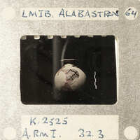 A vintage film strip with a photograph of an object resembling a human skull.