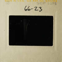 The image shows an old photograph with a black border and a handwritten note on the front, placed within a cardboard frame.