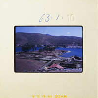 Aerial view of a coastal landscape with buildings and trees.