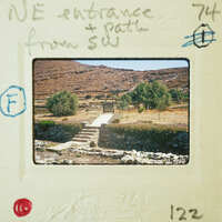 A vintage photograph of a stone staircase leading to a mountainous landscape, with handwritten annotations on the border.