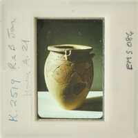 Ancient ceramic pot with visible cracks and designs on its surface.