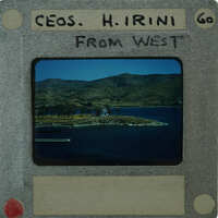 A photograph of a scenic landscape with mountains, water, and a small island, enclosed within an old-fashioned film clapperboard with handwritten notes.