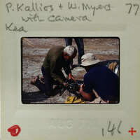 Two men working on a piece of equipment, possibly film or photography related.