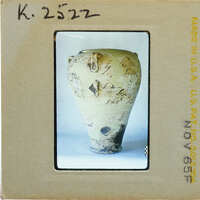 Ancient vase (K.2522) with markings on a white surface.