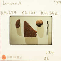 A photograph featuring two brown, triangular-shaped objects on a white surface with a ruler and labels indicating measurements.