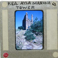 Old slide of a stone tower with trees and sky.