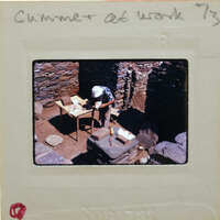 A person working on a stone structure with tools and materials.