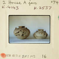 Two small vases with designs on display.