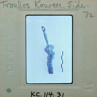 Small figurine with raised arms, possibly depicting a humanoid figure, on a white background.