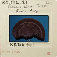 Broken circular object on blue background with handwritten notes and stamps.