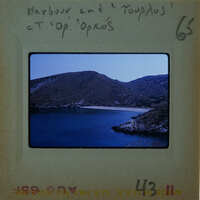 A photograph of a scenic bay with mountains and water, labeled "Marina and Toupelos" on a film strip.