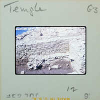 Old, crumbling stone ruins of a temple with vegetation growing on them.