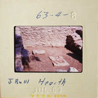 Old stone ruins with vegetation, captured on a vintage film strip.