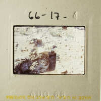 A vintage photograph of an outdoor scene with rocks and dirt, possibly taken from inside a vehicle.