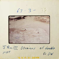 A photograph of an ancient rock surface with markings, possibly from an archaeological site.