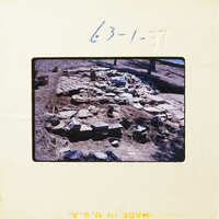 A photograph showing an archaeological excavation site with exposed stone structures and layers.