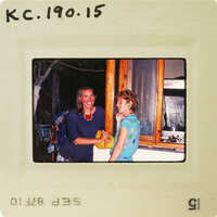 Two women shaking hands with smiles on their faces, captured in a vintage photo. Catalog number KC.190.15