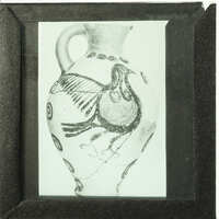 A framed photograph of an ancient Greek vase with a bird design.