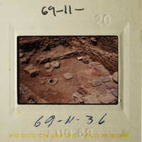 The photo shows an archaeological site with stone ruins and artifacts.