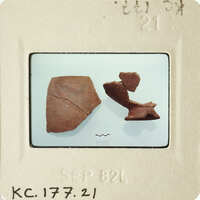 Two broken pottery pieces on a white surface.