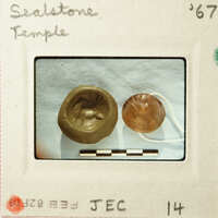 Two ancient coins with engravings, photographed against a white background.