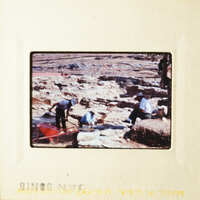 People working on an excavation site with tools and dirt.