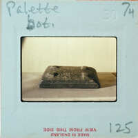 Small square object with bumps in corners.