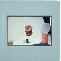 A photograph of a clay face mask on display.