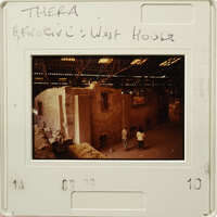 A photograph showing an old building with people standing outside, possibly taken from a vintage film strip.