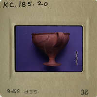 Ancient clay cup with handle on display.